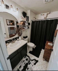 a bathroom with a black and white rug on the floor next to a shower curtain