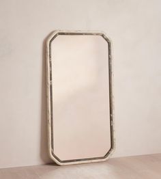 a mirror on the wall next to a wooden table