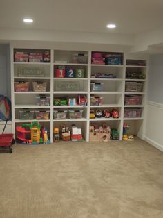 a room filled with lots of shelves and toys on top of carpeted flooring