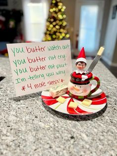 an elf is sitting on top of a coffee cup and saucer next to a sign that says you butter watch out