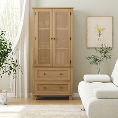 a white couch sitting next to a wooden cabinet