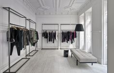 a clothing store with white walls and wooden floors