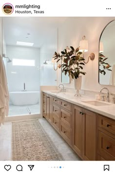 a bathroom with two sinks and a bathtub next to a large mirror on the wall