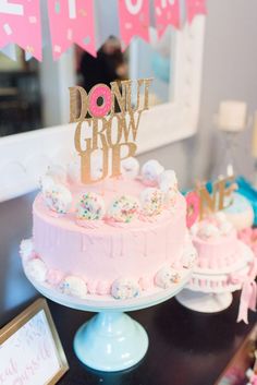 a pink cake sitting on top of a table