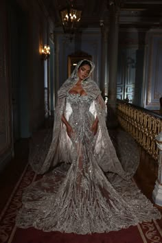 a woman in a silver gown and cape