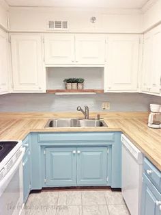 an empty kitchen with blue cabinets and white appliances on the counter tops, along with a stove top oven