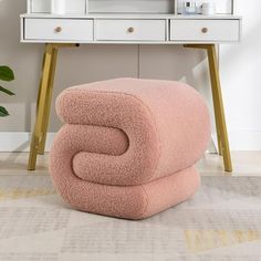 a pink chair sitting in front of a mirror on top of a wooden table next to a white dresser