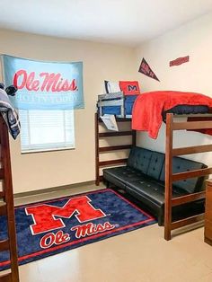 a room with bunk beds, desks and rugs on the floor in front of a window