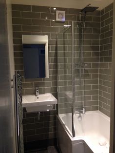 a bathroom with a sink, mirror and bathtub next to the shower stall is shown