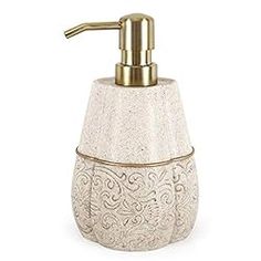 a white soap dispenser with gold accents