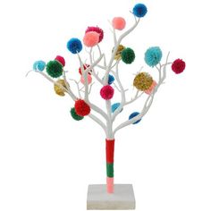 a white tree with multi colored pom - poms on it