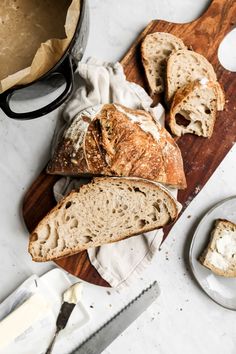 bread and butter on a cutting board next to a knife