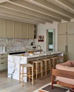 a kitchen with marble counter tops and wooden stools