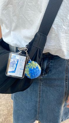 a person with a cell phone in their back pocket holding a small ball and chain