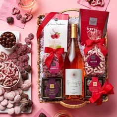 a basket filled with wine, chocolates and candies