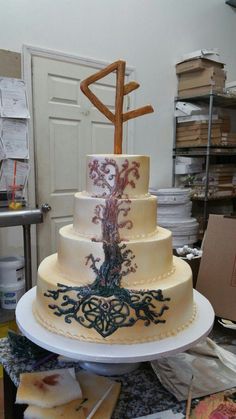 a three tiered cake sitting on top of a table next to stacks of papers