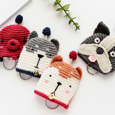 three crocheted animal key fobs on a white surface next to a plant