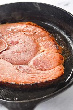 pork roasting in a skillet on a stove top with some seasoning sprinkles