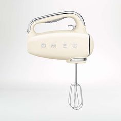 an electric hand mixer with the word smeg on it's front and side