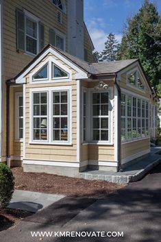 a yellow house with white trim and windows