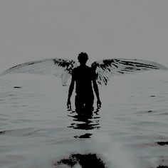 an angel standing in the water with its wings spread