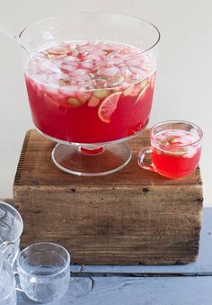 a pitcher filled with red liquid and garnished with fruit