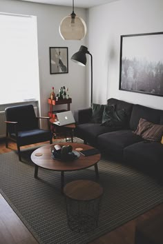 a living room filled with furniture and a laptop computer on top of a coffee table