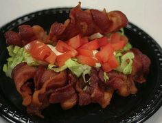 bacon and lettuce salad on a black plate