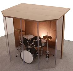 a drum set is in the middle of a room with glass partitions to it