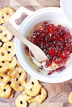 baked brie and sweet pepper jelly in a bowl with crackers on the side