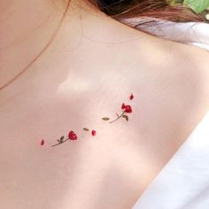 the back of a woman's shoulder with red flowers on her left arm and chest