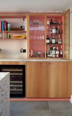 a kitchen with wooden cabinets and shelves filled with bottles