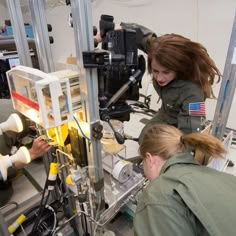 two women working on an assembly line in a factory, one woman is looking at the machine