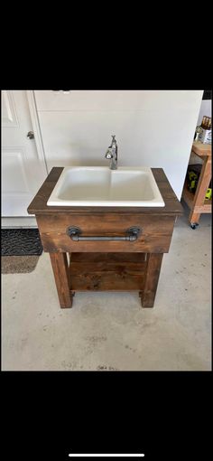 a sink made out of wood with a white counter top and two drawers underneath it