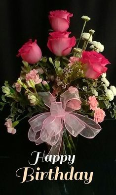 a vase filled with pink roses and white carnations