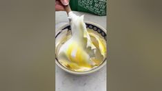 someone is peeling an onion in a bowl with butter and mayonnaise on the side