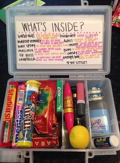 an open lunch box with candy, candies and other items in it that are labeled what's inside?