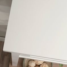 a white refrigerator freezer sitting on top of a wooden floor next to a counter