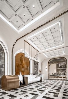 an elegant lobby with black and white checkered flooring, chandeliers and large windows