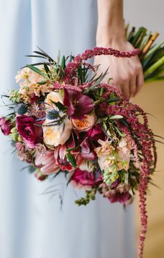 a woman holding a bouquet of flowers in her hands