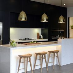 a kitchen with three stools next to an island