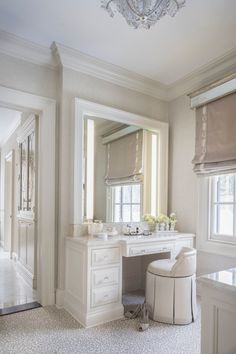 an elegant bathroom with white furniture and chandelier