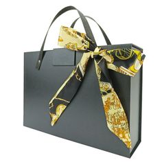 a black shopping bag with a yellow tie on it