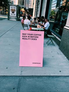 a pink sign that says may you coffee kick in before reality does on the sidewalk