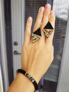 a woman's hand holding two bracelets with multicolored beads on them