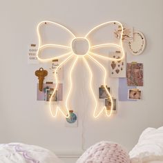 a bedroom with a bow shaped light hanging from the wall and pictures on the wall