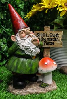 a garden gnome sitting next to a sign that says shh - h quiet the garden please