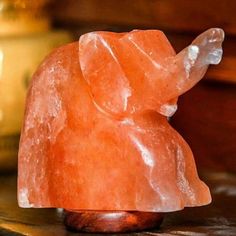 an elephant shaped rock sitting on top of a wooden table next to a lit candle