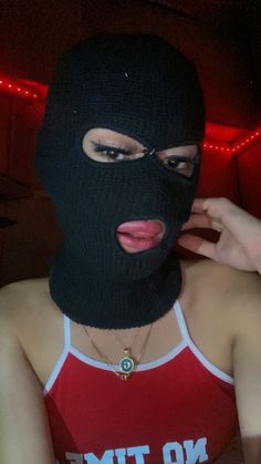 a woman wearing a black mask and red tank top