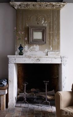 a living room with a fire place and a mirror on the wall above it's mantle